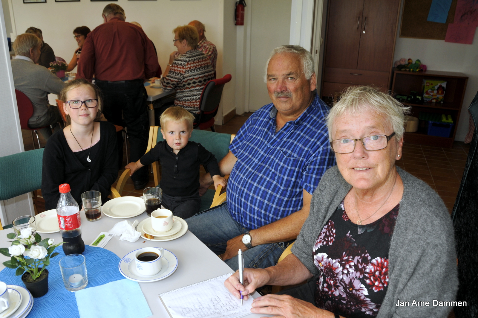 Ida og Marius koser seg med vafler og is sammen med morfar Olav Kvam, mens tante Inger skriver seg inn i boka som alle oppfordres til å gjøre på Kafe Mekken. Foto Jan Arne Dammen