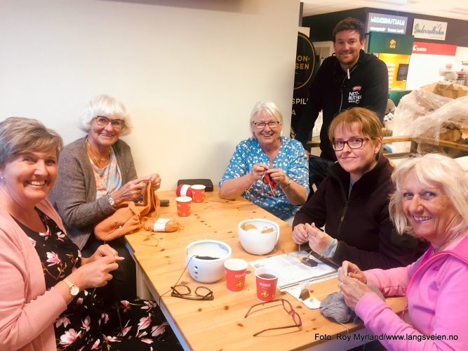 Strikker. Foto Roy Myrland "Dra'te Hæljeroa" og Søndersrødtunet, -stedet hvor folk møtes. -Der det er strikke-cafe hver onsdag kveld og praten går både løst og ledig. Det gjør strikkepinnene også.  Strikkecafeen har holdt på i flere år på Søndersrødtunet. Kjøpmann Dag Arild Bakken forteller til nettavisa Langsveien.no: Dette er noe av det viktigste jeg legger til rette for i og rundt butikken. Det at folk møtes og kan prate om stort og smått, ha det hyggelig og samtidig inkludere og bidra til at samfunnet vårt her på "solkysten" lengst sør i Vestfold blir enda litt bedre, er det viktig og gruelig moro å være med på. På bildet over fra venstre: Lillian Tvetene, som strikke Marius genser til sin sønn Jens Martin. Toril Brathagen jobber med moteriktig strikketøy. Det skal bli sommergenser i årets sommerfarger forteller hun. Gunbjørg Wirgenes strikke bunadsjakke til barn, men er også opptatt av bunader. Valdres folkemuseum sin bunadssamling er et sted hun kunne tenkt seg og vært en tur. Catharina Darre strikker kofte. Det er Vilde som skal få genseren Laila Aske Johansen så fint strikker-. Avdelingsleder Thomas Berntzen er "hanen i kørja" denne kvelden og sørger for de strikkelgade jentene får både litt ekstra oppmerksomhet og gratis kaffe når de møtes.