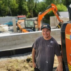 Dyktig og nøyaktig fagmann med gravemaskin, traktor og tilhenger.