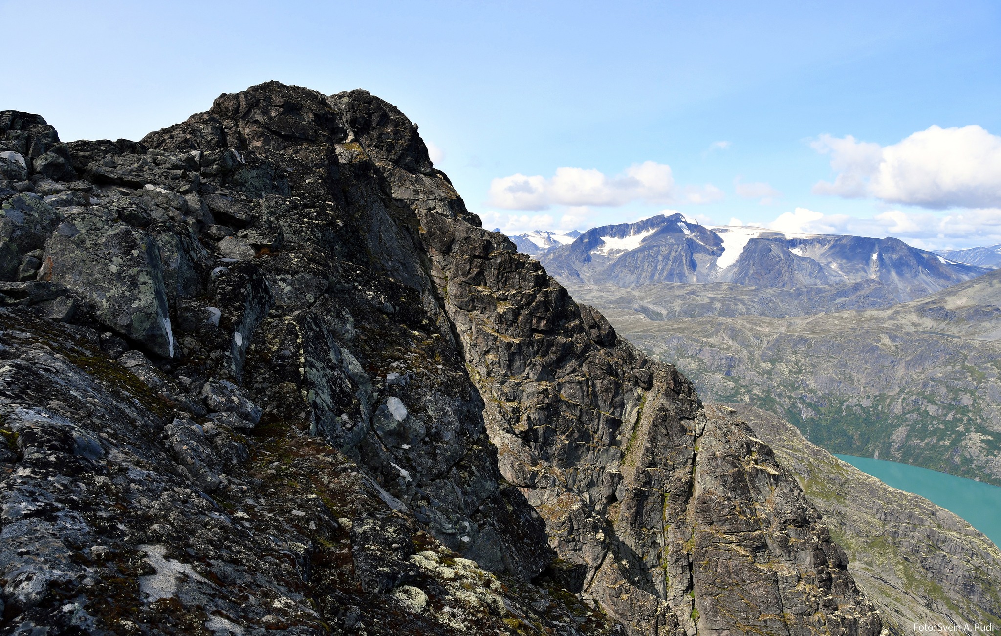 Høyeste punkt på Bukkehåmåren ruver majestetisk og truende i terrenget. I bakgrunnen ser man Surtningssue (2368 moh)